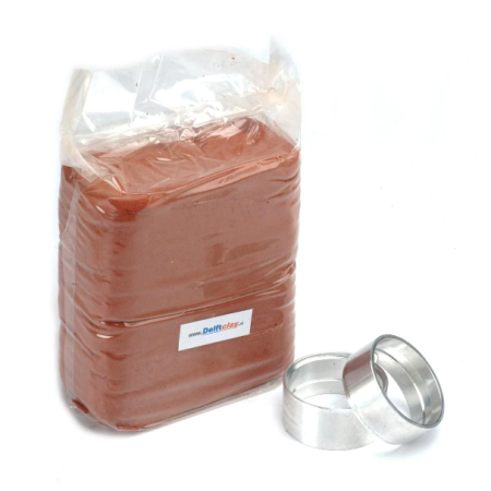 Delft™ Clay Casting Kit with clay, setting rings, and instructions on a crafting surface.